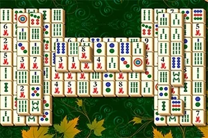 Mahjong csempe elrendezés zöld háttérrel és sárga levelekkel az alján