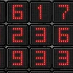 Világító piros számjegyek fekete háttérrel ellátott négyzetrácsos kijelzőn