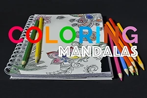 Spirálfüzet színes ceruzákkal és részben kiszínezett mandala mintával