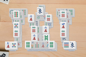 Mahjong lapkák különböző mintákkal és szimbólumokkal, fa asztalon elrendezve