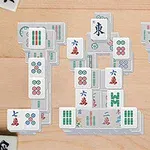 Mahjong lapkák különböző mintákkal és szimbólumokkal, fa asztalon elrendezve