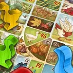 Színes madár alakú bábuk egy táblajáték illusztrált mezőin