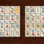 Két sorban elrendezett mahjong lapkák különböző szimbólumokkal és karakterekkel egy barna háttéren