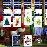 Játékasztal karácsonyi témájú kártyalapokkal, háttérben karácsonyi díszítéssel és emberekkel