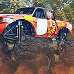 Piros és narancssárga színű monster truck nagy kerekekkel, amint egy poros és erdős terepen halad