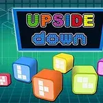 Fekete táblán színes UPSIDE down felirat látható, körülötte különböző színű és formájú kockák lebegnek zöld hátérrel